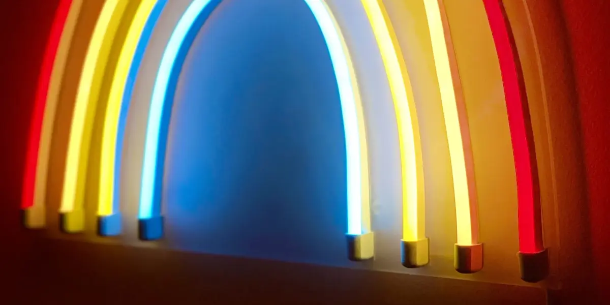 Glowing neon rainbow light on a red wall