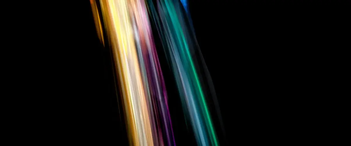 Colourful dice tumbling in streaks of light on a dark background